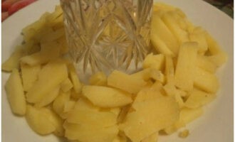 Ta ett fat och ställ ett glas i mitten. Vi bildar ett potatisskikt runt det.