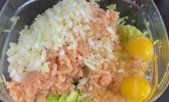 Magdagdag ng tinadtad na karne, tinadtad na sibuyas at mga itlog ng manok sa kinatas na zucchini.