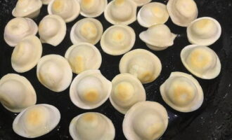 Hetta upp lite vegetabilisk olja i en stor stekpanna, tillsätt de frysta dumplingsna och stek under omrörning på måttlig värme i 2-3 minuter tills de är gyllenbruna på båda sidor.