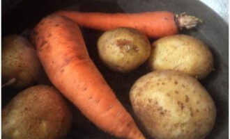 Tvätta morötterna och potatisen väl. Lägg i en kastrull med vatten och ställ i eld. Sänk värmen till måttlig efter kokning. Koka i en tredjedel av en timme. Efter att ha kontrollerat beredskapen, häll av vattnet och kyl grönsakerna.