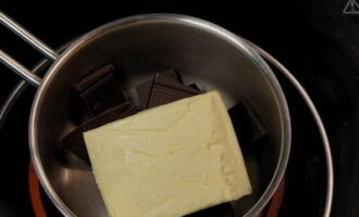 Lägg smör och mörk chokladbitar i en kastrull över vattenbad.