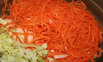 Ilagay ang repolyo sa isang malalim na mangkok at magdagdag ng mga Korean carrot dito.