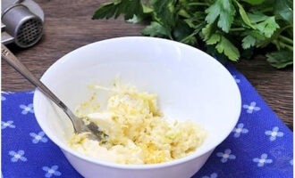 Sa isang malalim na plato, paghaluin ang pinalambot na mantikilya na may lemon zest at tinadtad na mga clove ng bawang.