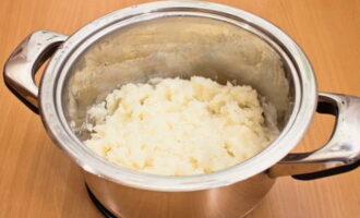 Escorreu el líquid de les patates cuites. Tritureu les patates amb un puré fins que quedin puré.