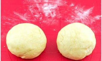 Pudra arbetsytan med mjöl och lägg ut basen, dela den i två delar och forma en boll av varje.Täck med en servett och ställ i kylen i 30-40 minuter.