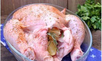 Maglagay ng mga hiwa ng lemon at isang sprig ng rosemary sa loob ng manok para sa lasa.