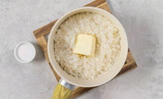 Pagkatapos ay lutuin na natatakpan sa napakababang apoy para sa isa pang 25 minuto. Pagkatapos ay patayin ang apoy at iwanan ang kanin na natatakpan para sa isa pang 15 minuto. Gumalaw sa isang piraso ng mantikilya dito.