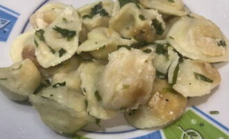 Lägg friterade dumplings med gräddfil i en stekpanna i portionerade tallrikar och servera varma till bordet. Smaklig måltid!
