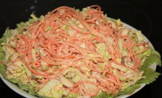 Ilagay ang mga dahon ng repolyo sa isang serving plate. Inilipat namin ang handa na salad sa kanila.