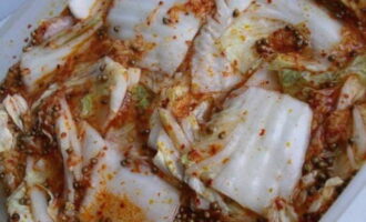 Đặt bắp cải vào thùng chứa và đổ nước sốt đã chuẩn bị sẵn. Để lại ở nhiệt độ phòng trong một đến hai ngày, sau đó cho vào tủ lạnh.