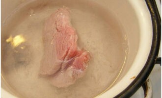 Egy külön serpenyőben forraljunk fel fél liter vizet, és adjunk hozzá egy kis sót. A marhahúst forrásban lévő vízbe tesszük, és lefedve, lassú tűzön fél óráig főzzük. Ezután hűtsük le a húst.