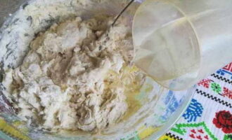 Sau đó đổ dầu thực vật vào bột và dùng thìa trộn đều lại.