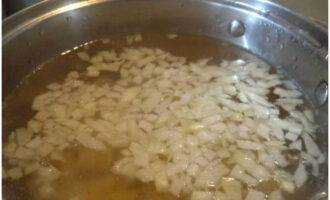 Efter 5 minuter från början av kokningen av potatisen, lägg den hackade löken i pannan och fortsätt att koka soppan, täckt, i 10-15 minuter.