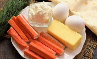 Cách làm món bánh cuộn pita với que cua và phô mai? Chúng tôi sẽ chuẩn bị các sản phẩm cần thiết theo danh sách. Luộc trứng gà trước và để nguội.