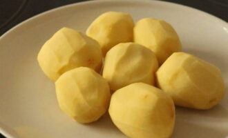 Les patates fregides en una paella es preparen de manera ràpida i senzilla. Peleu les patates i esbandiu-les sota aigua.