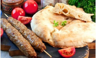 Lula kebab đã sẵn sàng trong lò nướng ở nhà. Ăn kèm bánh mì pita và rau tươi!