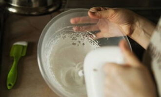 Låt de återstående 60 gram proteinerna skumma. För långsamt in den varma sirapen i mitten, utan att sluta använda mixern, vispa i 10 minuter tills marängen svalnar.