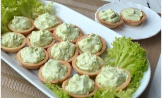 Cobriu el plat amb fulles d'enciam, prèviament rentades i assecades. Distribuïu les tartaletes. Ompliu una manga pastissera amb el farcit cremós i introduïu la nata a les tartaletes.