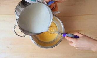 Ibuhos ang kalahati ng mainit na gatas sa pinaghalong itlog sa isang manipis na stream habang hinahalo.