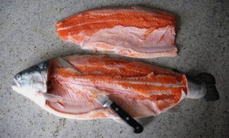 Hoe kun je thuis snel en smakelijk forel inmaken? Snijd het forelkarkas, scheid de filet van de botten en de huid.