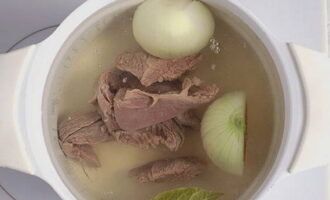 Gooi de plakjes rundvlees, laurierblaadjes en uien in kokend water en laat 60 minuten op laag vuur koken, waarbij je al het schuim verwijdert met een schuimspaan. Voeg 10 minuten na het koken verse peterseliestengels toe aan de bouillon.