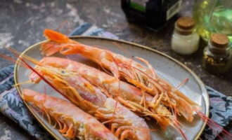 Cách nấu tôm nước tương với tỏi trên chảo rán? Đổ nước lên tôm đã rã đông trước và thấm khô bằng khăn ăn.