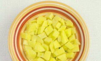 Sa oras na ito, alisan ng balat ang mga patatas, banlawan sa ilalim ng tubig at gupitin sa mga cube.