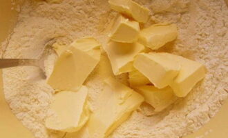 Đặt miếng bơ vào hỗn hợp khô. Chúng tôi dành 30 gram bơ cho kem.