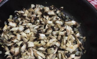 Skala löken och hacka fint. Tvätta champinjonerna och skär i tärningar. Stek löken i vegetabilisk olja i 5 minuter, rör om med en spatel. Tillsätt sedan svampen och koka i ytterligare 5 minuter.