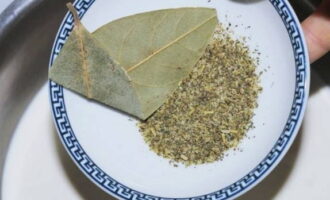 Tillsätt salt, mald svartpeppar, torkade örter och lagerblad till den uppvärmda grädden.