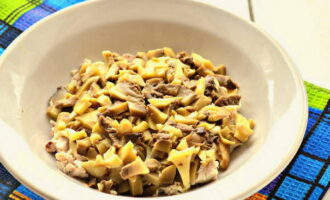 Ilagay ang susunod na layer ng diced pickled mushroom; lagyan din ng mayonnaise ang layer.