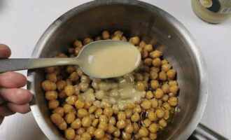 Alisan ng tubig ang mga chickpeas sa isang hiwalay na mangkok. Kakailanganin natin ang decoction mamaya. Magdagdag ng tahini (sesame paste) sa mga chickpeas. Kung wala kang tahini, maaari mong i-toast ang mga linga sa isang kawali at gilingin ito sa isang blender na may langis ng oliba.
