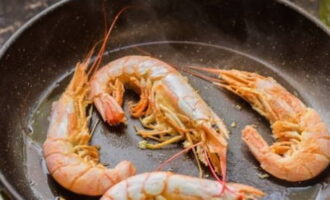 Sau khi hơi ẩm bốc hơi hết, đổ một ít dầu hướng dương vào tôm.