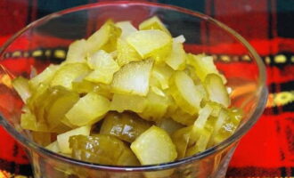 Talleu els cogombres en escabetx a trossos petits. Bulliu-los lleugerament a foc lent en una paella amb salmorra de cogombre.