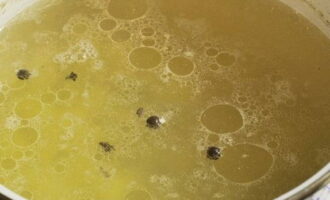 A burgonyakockákat forrásban lévő csirkehúslevesbe tesszük, és beletesszük a borsot és a szegfűszeget.