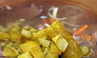 Aboqueu els cogombres i la salmorra a la nostra sopa. Coure fins que el cereal estigui tou i apagueu el foc.