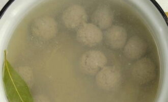 Pakuluan ang tubig sa isang kasirola, magdagdag ng dahon ng bay, asin at paminta. Maingat na ilagay ang mga bola-bola sa tubig na kumukulo at pakuluan muli ang lahat.