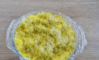 Finalment, estireu els escabetx i les patates ratllades, cobriu les capes amb salsa blanca.