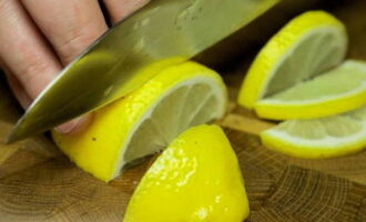 Hoe sappige roze zalm in folie in de oven koken? Citroenen moeten grondig worden gewassen met heet water, of beter nog, worden gespoeld met kokend water om alle chemische behandelingen van het oppervlak van de schil te verwijderen. Snijd een citroen in de lengte doormidden en snijd vervolgens elke helft in niet te dunne plakjes. Snij de tweede citroen kruislings doormidden.