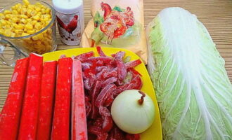 Salade met krabsticks en Chinese kool? Wij zijn een voedselpakket aan het voorbereiden. Verwijder de schil van de ui en was deze. Als we verse paprika's gebruiken, was deze dan, verwijder het binnenste en snijd ze in reepjes. Verwijder de verwelkte bovenste bladeren van de kool. We halen de voorgevroren krabsticks eruit en laten ze ontdooien. Giet de vloeistof uit de maïs af.