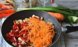 We vullen de kip aan met wortels en paprika. Roer de inhoud van de pan en kook nog eens 15 minuten.