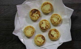Ta bort överflödig olja genom att överföra varma cheesecakes till en bunt pappersservetter.