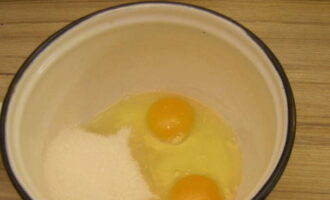 Kies een geschikte pan of steelpan voor het koken van de room. Breek hier de eieren en voeg kristalsuiker toe.