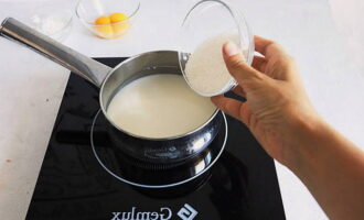 Đổ sữa vào muôi và thêm 30 gam đường cát. Đặt nó lên bếp và chờ cho nó sôi.