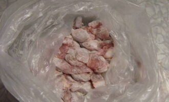 Doe het vleesproduct in een zak met bloem. Schud de inhoud van de verpakking actief. Dit zorgt ervoor dat het droge ingrediënt snel en gelijkmatig over alle stukken vlees wordt verdeeld.