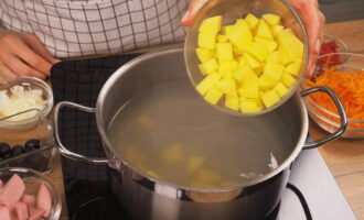 Zet de pan op het fornuis. Doe de aardappelschijfjes in de gezeefde, gekookte bouillon. We wachten tot het weer kookt en koken de aardappelen gedurende 20 minuten.