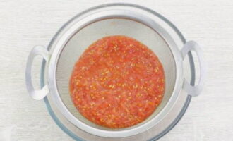 Wrijf deze tomatenmassa door een zeef zodat je ongeveer 400 ml tomatensap krijgt.