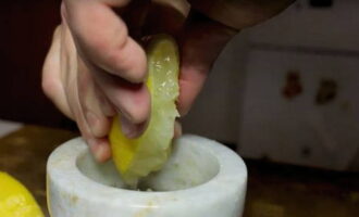 Verwijder de tijmblaadjes van de takjes en doe ze in een vijzel. Giet ook zout en versgemalen zwarte peper in de container, pers het sap van één citroen uit, zorg ervoor dat er geen citroenzaadjes in de marinade terechtkomen.