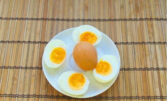 Kook tegelijkertijd de eieren zodat de dooier enigszins vloeibaar blijft. Afkoelen, schillen en in tweeën snijden.