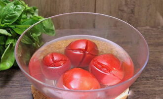 Chúng tôi thực hiện những vết cắt hình chữ thập trên cà chua đã rửa sạch và đổ nước sôi lên chúng. Sau 5 phút, rửa sạch dưới nước lạnh và loại bỏ da.